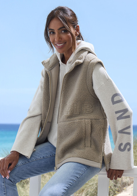 Bild: Fleeceweste von Elbsand: Fleeceweste aus Teddyplüsch von Elbsand. Mit hohem Kragen. Schriftzug-Stickerei vorn und hinten. Reißverschlüsse seitlich am Saum. Eingrifftaschen vorn. Weiche Fleece-Qualität.