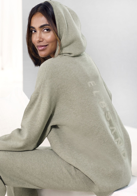 Bild: Hoodie von Elbsand: Weicher Strick-Hoodie von Elbsand. Mit eingestricktem Markenschriftzug hinten. Lange Ärmel mit überschnittenen Schulternähten. Aufgesetzte Kängurutasche vorn. Lockere Passform. Angenehm zu tragende Strickware mit hohem Viskose-Anteil.