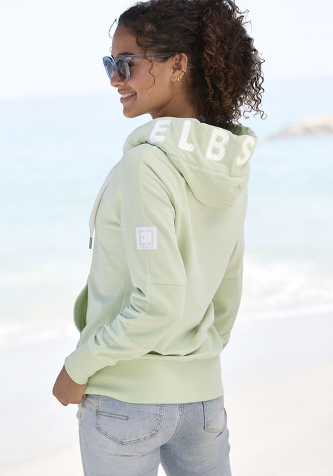 Bild: Kapuzensweatjacke von Elbsand: Lässiges Kapuzensweatshirt von Elbsand. Große Kapuze mit Tunnelzug und plakativem Labelschriftzug. Lange Ärmel mit überschnittenen Schultern. Breite Saumbündchen. Praktische Eingrifftaschen. Weiche, wärmende Sweatqualität.