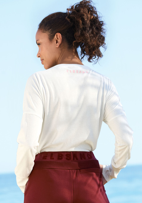 Bild: Langarmshirt von Elbsand: Lässiges Langarmshirt von Elbsand. Highlight: der weit geschnittene Rundhalsausschnitt. Mit überschnittenen Schultern und großem Logodruck vorn und kleinem im Nacken. Geräumige Oversize-Form, ideal für Casual-Looks. Anschmiegsame Jerseyqualität mit Baumwollanteil.