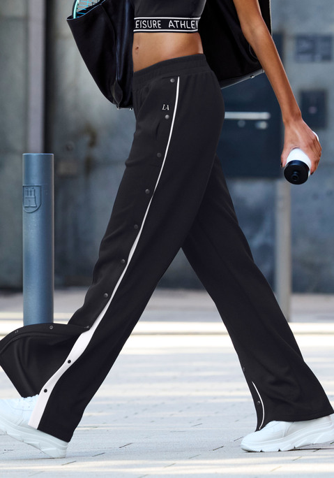 Bild: Jogginghose von LASCANA ACTIVE: Elegante Sporthose von Lascana Active. Das Besondere: das weite Bein und die Knöpfe an der Seitennaht. Weitere Details: Paspelierung entlang der Vorderseite der Beine und weißer Logo-Aufdruck oben an der linken Hüfte. Geraffter, elastischer Bund. Aus atmungsaktivem, elastischem Funktionsmaterial.