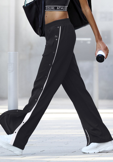 Bild: Jogginghose von LASCANA ACTIVE: Elegante Sporthose von Lascana Active. Das Besondere: das weite Bein und die Knöpfe an der Seitennaht. Weitere Details: Paspelierung entlang der Vorderseite der Beine und weißer Logo-Aufdruck oben an der linken Hüfte. Geraffter, elastischer Bund. Aus atmungsaktivem, elastischem Funktionsmaterial.