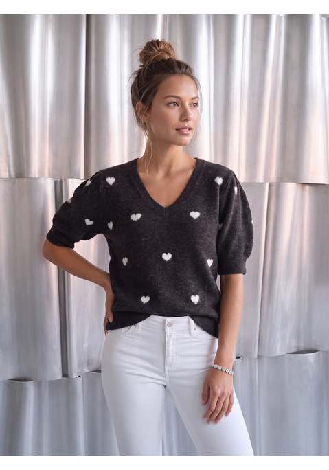 Bild: Kurzarmpullover von LASCANA: <b>Verspielte Frische: der Kurzarmpullover von Lascana mit charmantem Herzmuster</b><br><br>Der <b>Kurzarmpullover von Lascana</b> vereint kuschelige Strickqualität mit einem sommerlich leichten Kurzarm-Design und einem verspielten Herzchenmuster im Jacquard. Diese Kombination macht den Strickpullover zum perfekten Übergangsstück, das sich zwischen den Jahreszeiten stilvoll behaupten kann. Das Motiv bringt eine liebevoll-romantische Note in jeden Look.<br><br><b>Trendige Details und weiche Abschlüsse</b><br><br>Kurze Puffärmel setzen einen femininen Akzent und verleihen dem Oberteil eine moderne, verspielte Silhouette. Die gerade Passform schmeichelt der Figur und lässt sich vielseitig kombinieren. Weiche Rippstrickabschlüsse an Ärmeln und Saum runden das Modell sauber ab. Die hüftlange Länge harmoniert sowohl mit hoch geschnittenen als auch mit tief sitzenden Unterteilen. Das kuschelige Material fühlt sich angenehm auf der Haut an. Die Maschinenwäsche sorgt für unkomplizierte Pflege im Alltag.<br><br><b>Sommerliche und frühlingshafte Kombinationen</b><br><br>Zu einer Culotte-Jeans und weißen Sneakern entsteht ein frischer Frühlingslook für den Tag. Kombiniert mit einem plissierten Midirock und Ballerinas wirkt der Strickpulli besonders feminin und eignet sich für Brunchdates oder Café-Besuche. Über einer Slim-fit-Hose mit Loafern und Perlenohrringen gelingt ein eleganter Bürolook. Für laue Sommerabende harmoniert der Pullover mit Shorts aus Leinen und Riemchensandalen. Eine kleine Umhängetasche und ein feiner Ledergürtel komplettieren jedes Outfit.<br><br>Der <b>Kurzarmpullover von Lascana</b> ist ein charmanter Begleiter für stilbewusste Übergangstage.