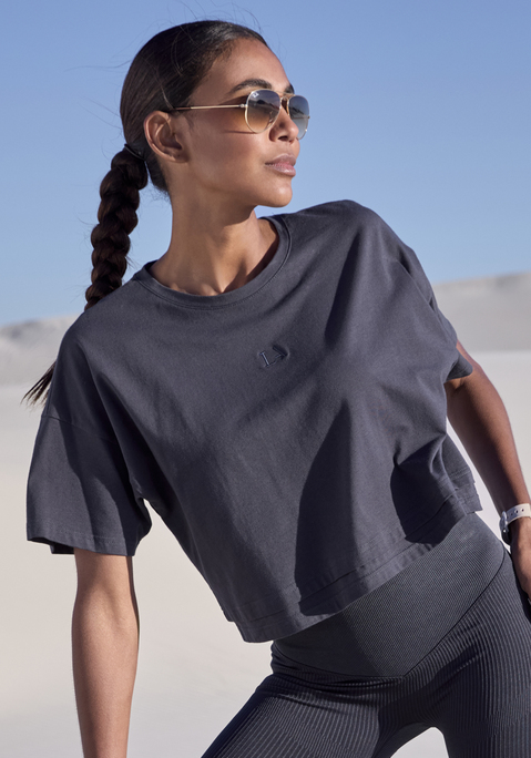 Bild: Kurzarmshirt von LASCANA: Lässiges Cropped-Shirt von Lascana mit Rundhalsausschnitt und lässig überschnittenen Schultern. Saum im Lagen-Look. Tonige Markenstickerei vorn. Weite, kastige Passform mit modisch verkürzter Länge. Elastischer Baumwolljersey.