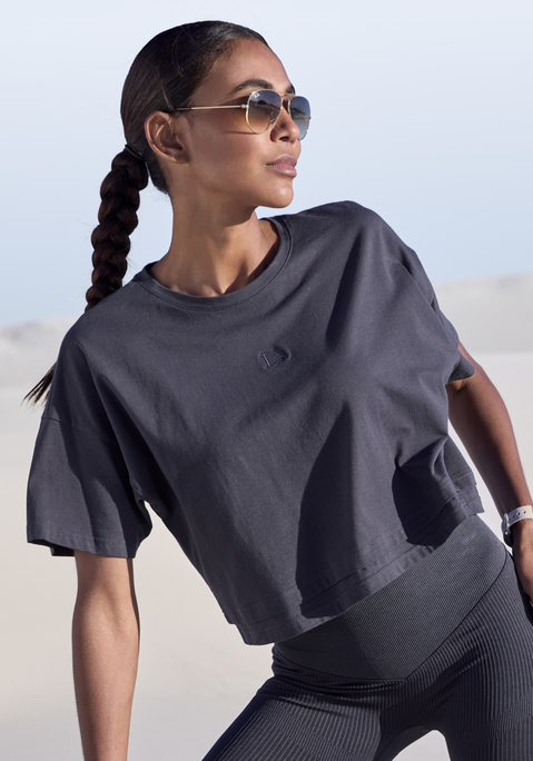 Bild: Kurzarmshirt von LASCANA: Lässiges Cropped-Shirt von Lascana mit Rundhalsausschnitt und lässig überschnittenen Schultern. Saum im Lagen-Look. Tonige Markenstickerei vorn. Weite, kastige Passform mit modisch verkürzter Länge. Elastischer Baumwolljersey.