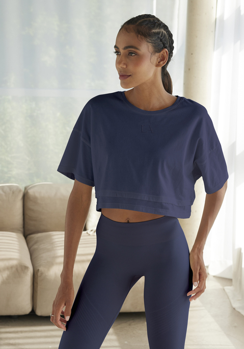 Bild: Kurzarmshirt von LASCANA: Lässiges Cropped-Shirt von Lascana mit Rundhalsausschnitt und lässig überschnittenen Schultern. Saum im Lagen-Look. Tonige Markenstickerei vorn. Weite, kastige Passform mit modisch verkürzter Länge. Elastischer Baumwolljersey.