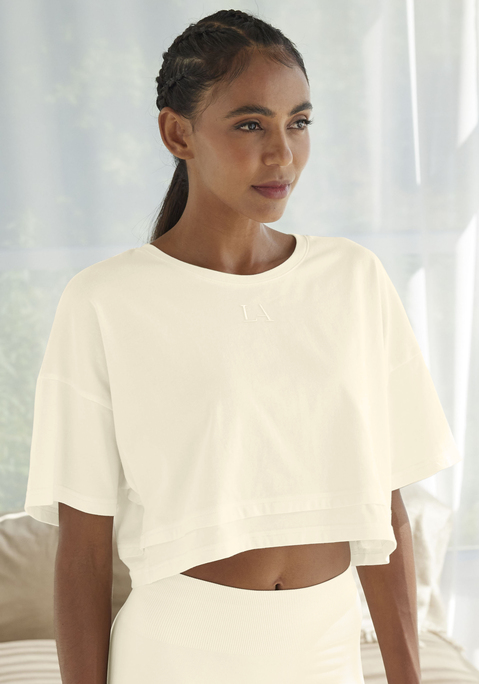 Bild: Kurzarmshirt von LASCANA: Lässiges Cropped-Shirt von Lascana mit Rundhalsausschnitt und lässig überschnittenen Schultern. Saum im Lagen-Look. Tonige Markenstickerei vorn. Weite, kastige Passform mit modisch verkürzter Länge. Elastischer Baumwolljersey.
