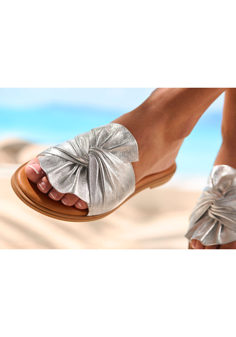 Bild: Pantolette von LASCANA: Pantolette von Lascana mit großem Schleifendetail. Metallisch glänzender, breiter Riemen. Leicht gepolsterte Innensohle für einen angenehmen Tragekomfort. Perfekt gestylt für den nächsten Sommer – mit Kleidern, Röcken oder Shorts. Obermaterial aus Lammleder. Futter aus Schweinsleder. Decksohle aus Rindsleder. Laufsohle aus Synthetik.