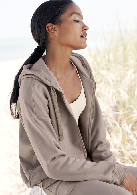 Bild: Sweatjacke von LASCANA: Homewear-Sweatjacke von Lascana. Gefütterte Kapuze mit Kordelzug. Durchgehender Reißverschluss. Tonige Markenstickerei. Angesetzte Rippbündchen. Bequeme Passform mit überschnittenen Schultern. Angenehme Baumwollqualität.