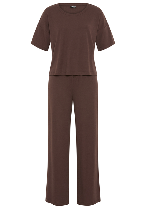 Bild: Pyjama von LSCN by LASCANA: Schlaf gut, träum schön! In diesem Pyjama von LSCN by Lascana wird Relaxen zum Style-Statement. Das locker geschnittene Shirt mit Rundhalsausschnitt, kurzen Ärmeln und überschnittenen Schultern bietet maximale Bewegungsfreiheit und einen entspannten Fit. Die passende Hose mit bequemem Gummizug sitzt angenehm an der Taille und punktet mit einem angedeuteten Eingriff samt Knopfleiste, ein lässiges Detail mit klassischem Touch. Das gerade geschnittene Bein rundet den Look ab und macht das Loungeset zur perfekten Mischung aus Komfort und Coolness. Mach die Nacht zu deinem Cozy-Moment – mit dem Pyjama von LSCN by Lascana.