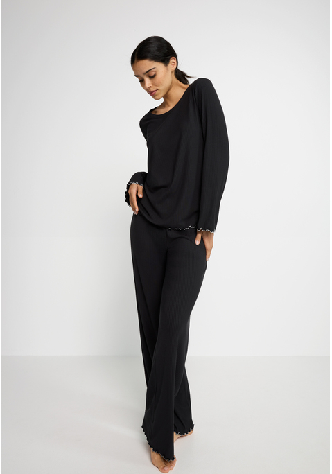 Bild: Pyjama von LSCN by LASCANA: Relaxen mit Style – der Pyjama von LSCN by Lascana ist die perfekte Kombination aus Komfort und trendigen Details. Das Langarmshirt mit Rundhalsausschnitt und legerem Fit sorgt für ein entspanntes Tragegefühl, das dich durch den ganzen Tag begleitet – oder eben durch die ganze Nacht. Die Hose mit elastischem Bund und Tunnelzug passt sich deinem Körper an und garantiert dabei maximalen Komfort. Die weiche Rippware umhüllt dich sanft, während die Kontrast-Kräsuselkanten dem Set das gewisse Etwas verleihen. Ein Set, das nicht nur bequem ist, sondern auch mit modernen Details überzeugt – der Pyjama von LSCN by Lascana.