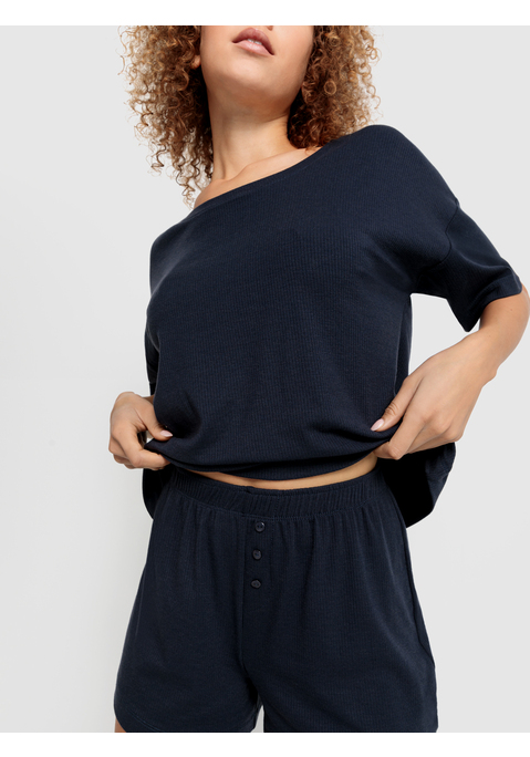 Bild: Shorty von LSCN by LASCANA: Lässiger Look, maximaler Komfort: Der Shorty von LSCN by Lascana bringt dich in den perfekten Chill-Modus. Das kurze, leger geschnittene Halbarmshirt mit überschnittenen Schultern bietet dir eine entspannte Passform, die dich nicht nur nachts, sondern auch beim Relaxen zu Hause begleitet. Die Shorts mit geradem Bein und einer kurzen Zier-Knopfleiste setzen ein süßes Detail und sorgen für einen coolen Look. Die weiche, elastische Rippqualität fühlt sich richtig angenehm auf der Haut an. Dadurch ist der Pyjama perfekt für gemütliche Abende. Kuschel dich ein und genieße den Komfort – mit dem Shorty von LSCN by Lascana.