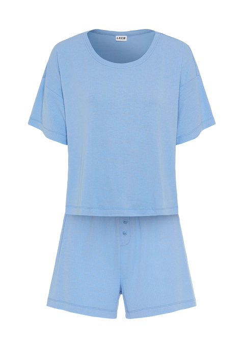 Bild: Shorty von LSCN by LASCANA: Lässiger Look, maximaler Komfort: Der Shorty von LSCN by Lascana bringt dich in den perfekten Chill-Modus. Das kurze, leger geschnittene Halbarmshirt mit überschnittenen Schultern bietet dir eine entspannte Passform, die dich nicht nur nachts, sondern auch beim Relaxen zu Hause begleitet. Die Shorts mit geradem Bein und einer kurzen Zier-Knopfleiste setzen ein süßes Detail und sorgen für einen coolen Look. Die weiche, elastische Rippqualität fühlt sich richtig angenehm auf der Haut an. Dadurch ist der Pyjama perfekt für gemütliche Abende. Kuschel dich ein und genieße den Komfort – mit dem Shorty von LSCN by Lascana.