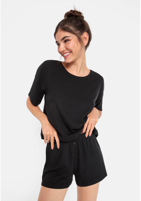 Bild: Shorty von LSCN by LASCANA: Lässiger Look, maximaler Komfort: Der Shorty von LSCN by Lascana bringt dich in den perfekten Chill-Modus. Das kurze, leger geschnittene Halbarmshirt mit überschnittenen Schultern bietet dir eine entspannte Passform, die dich nicht nur nachts, sondern auch beim Relaxen zu Hause begleitet. Die Shorts mit geradem Bein und einer kurzen Zier-Knopfleiste setzen ein süßes Detail und sorgen für einen coolen Look. Die weiche, elastische Rippqualität fühlt sich richtig angenehm auf der Haut an. Dadurch ist der Pyjama perfekt für gemütliche Abende. Kuschel dich ein und genieße den Komfort – mit dem Shorty von LSCN by Lascana.