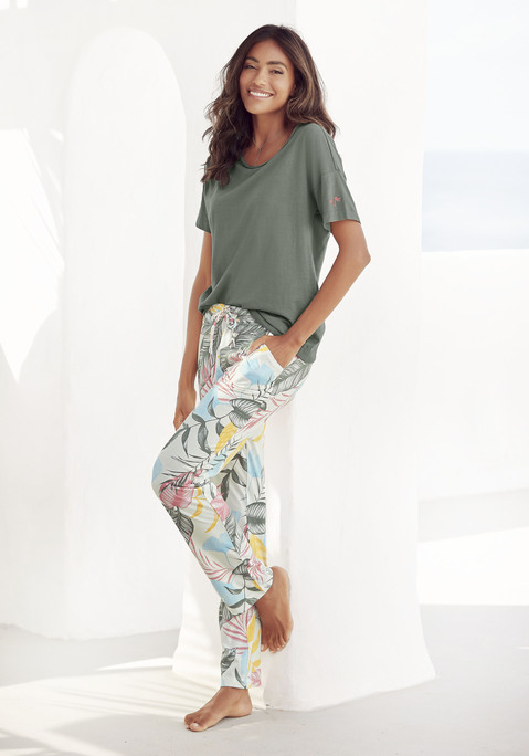 Bild: Pyjama von Vivance Dreams: Tropischer Pyjama von Vivance Dreams. Unifarbenes Kurzarmshirt mit Braids entlang des Rundhalsausschnitts und Stickerei am linken Ärmel. Gemusterte, knöchellange Hose mit elastischem Tunnelzugbund und seitlichen Eingrifftaschen. Single-Jersey-Qualität aus Baumwoll-Viskosemix.